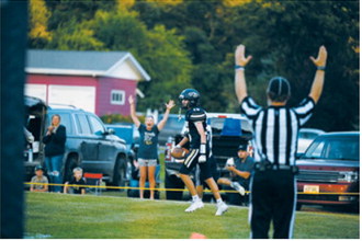 North Border’s Asher Crosby, No. 15, celebrates a touchdown against the North Prairie Cougars on Friday, Aug. 21, in Pembina. Photo by Ashley Schafer