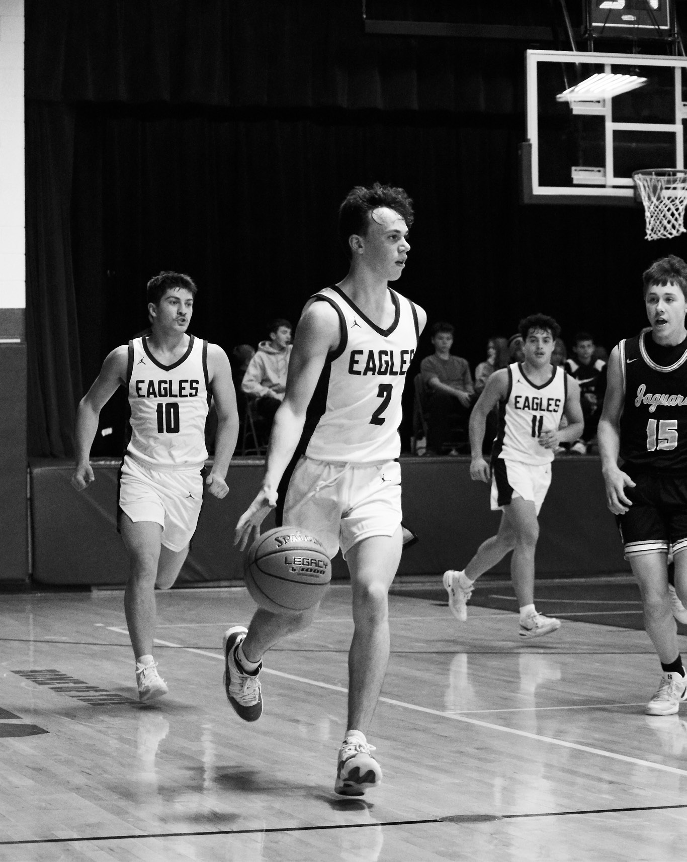 Kaden Moore takes the ball down the court. Photo by Ashley Schafer.
