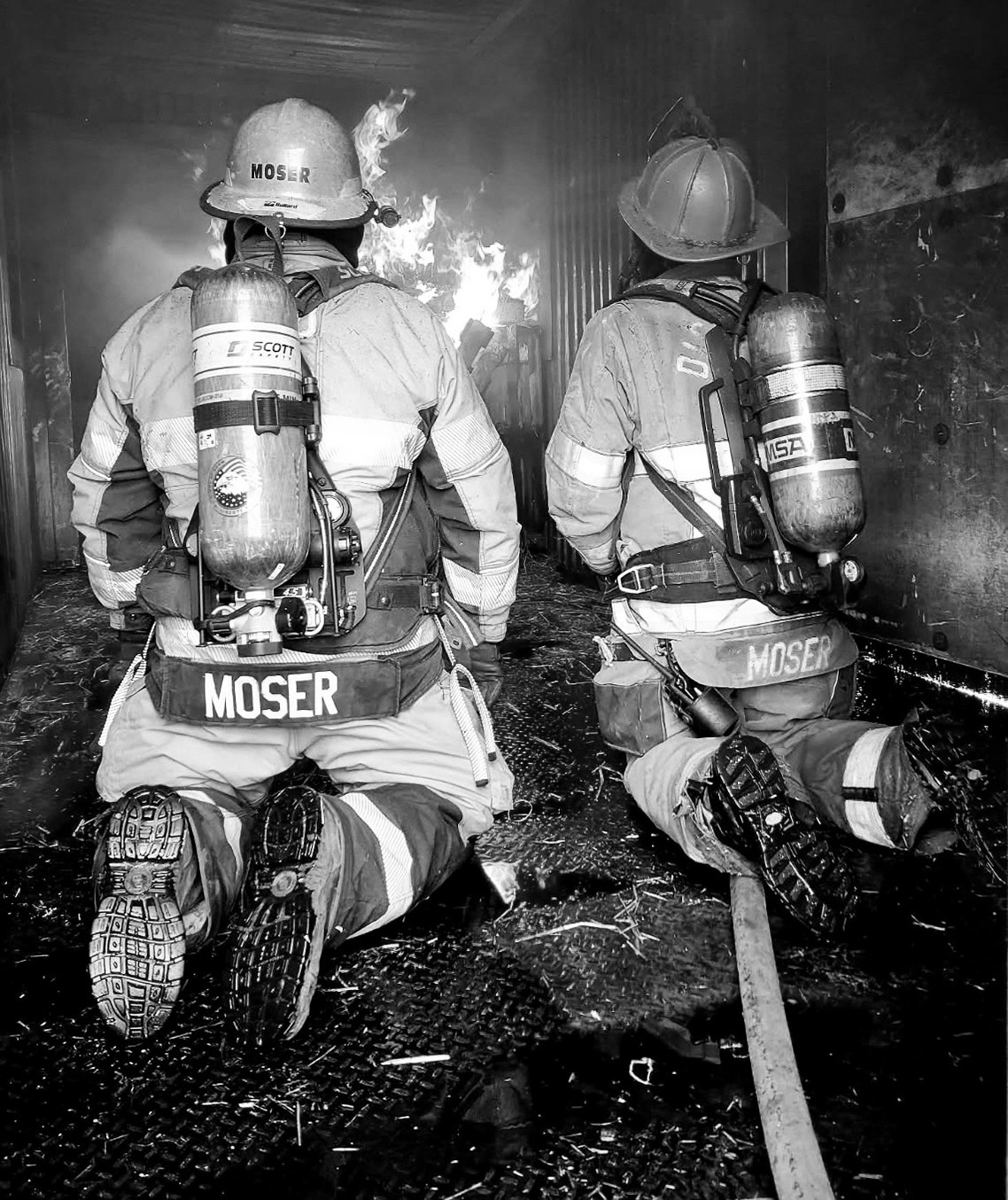 Nick Moser, left, and his nephew, Hunter Moser, both nationally certified fire instructors, work together during structural live-fire training Aug. 8 in Cavalier. Firefighters from seven North Dakota communities participated in the exercise.