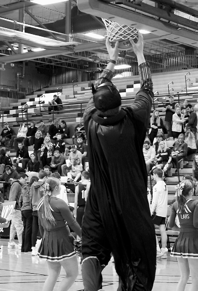 When the ball got caught in the net at the Regional Tournament on March 10, luckily a super hero (Landon Schneider) was watching and sprung into action to untangle the ball. Photo by Larry Stokke.