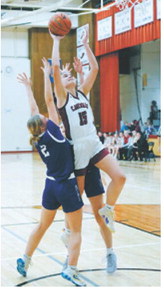 Taya Feist cuts through two defenders and drops in a basket and had a great game, ending the night with 10 points. Photo by Larry Stokke