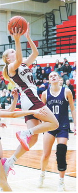 Hilary Haaven slides through three Bottineau players and lays in a basket. Photo by Larry Stokke