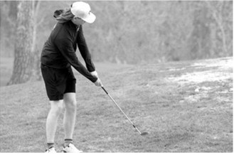 Zander Duerre chips the ball onto the green and close to the pin during the Larimore meet. Photo by Larry Stokke