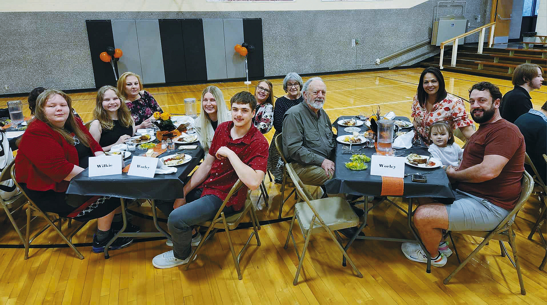 Edmore’s two seniors, Alexis Wilkie and Rayce Worley (leftside table, front), surrounded by their families for the special evening. Photo by Hilary Nowatzki.