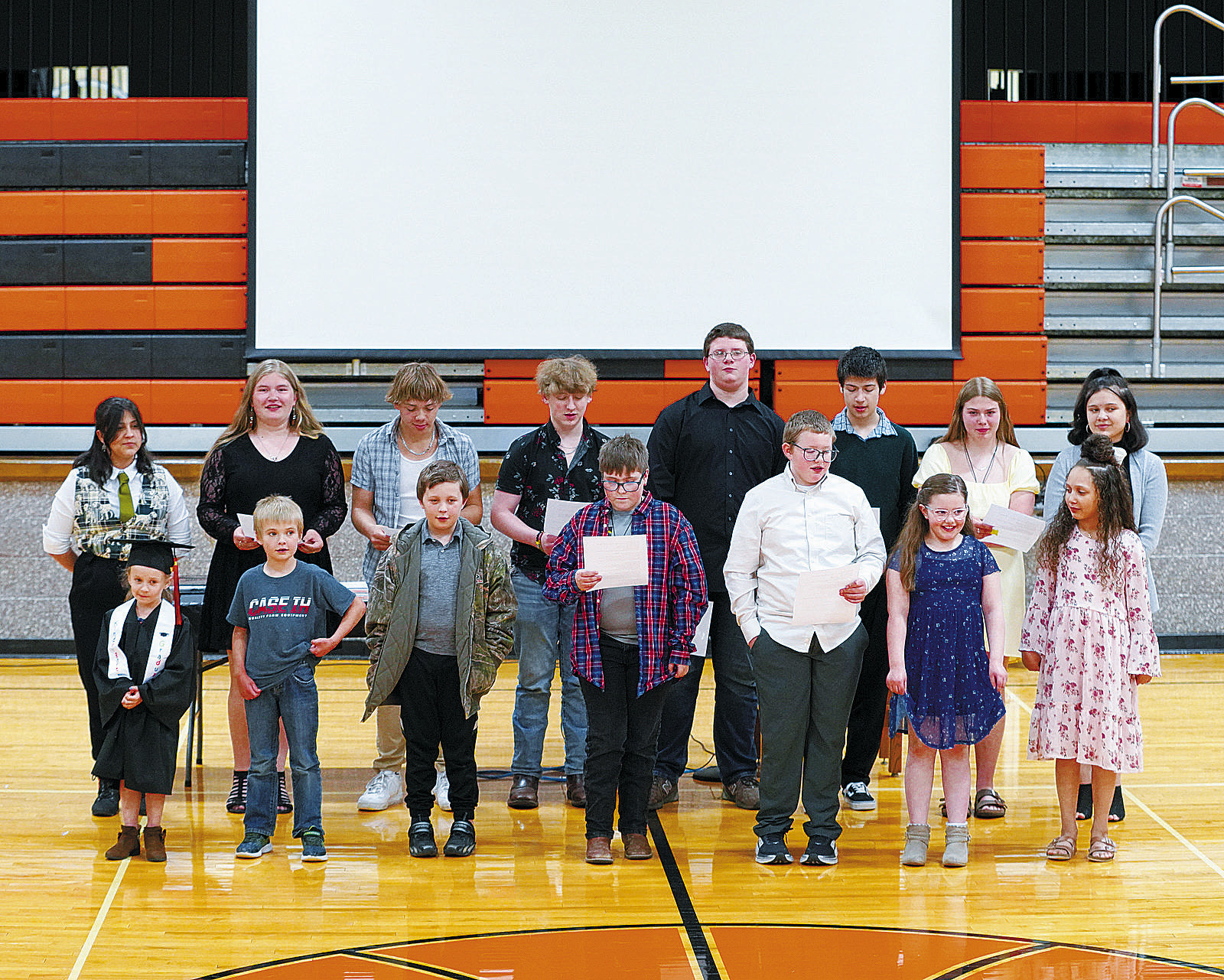 As part of the ceremony, the school's single kindergartener, Haisley Boehmer (front left), is joined by her fellow schoolmates to sing a tribute song. Photo by Larry Stokke.