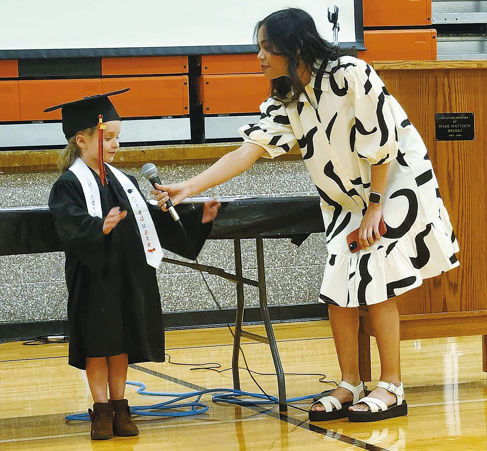 Ms. Umali hands off the microphone to her kindergarten student. Photo by Hilary Nowatzki.