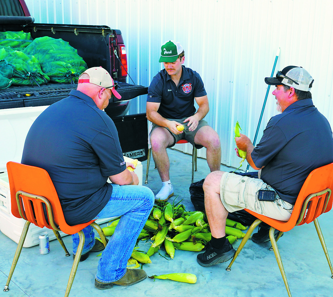 Firefighters shucking corn for their annual fundraiser. Photo by Larry Stokke.
