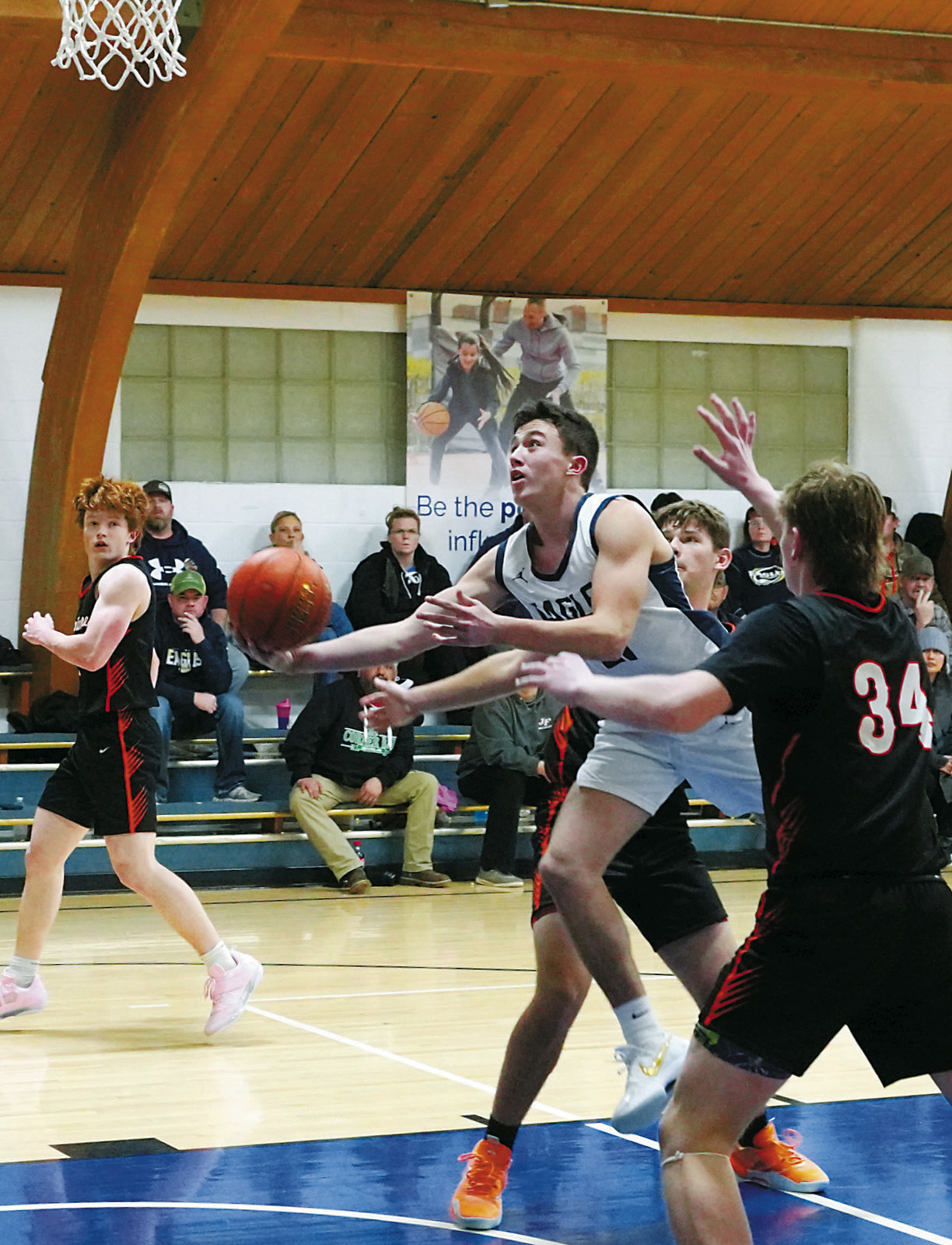 Brody Berg drives through two Polar Bear defenders and lays in a basket in the Eagles' win over Larimore. Photo by Larry Stokke.