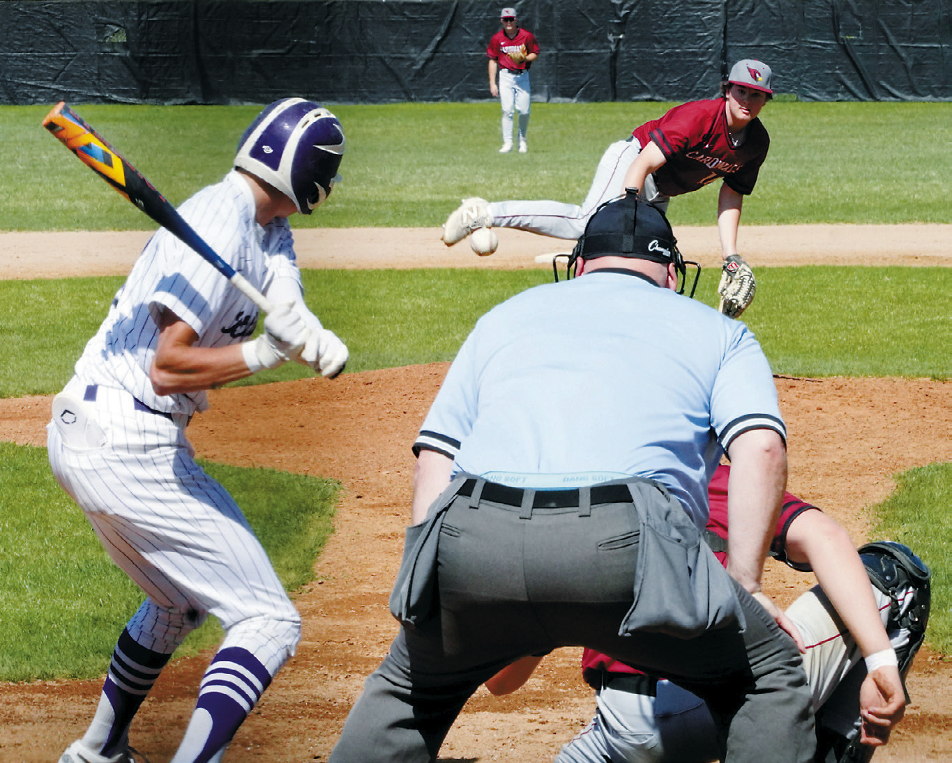 Devin Hakanson delivers a strike to a Bottineau payer in the Cards' win in Bottineau on May 10. Photo by Larry Stokke.