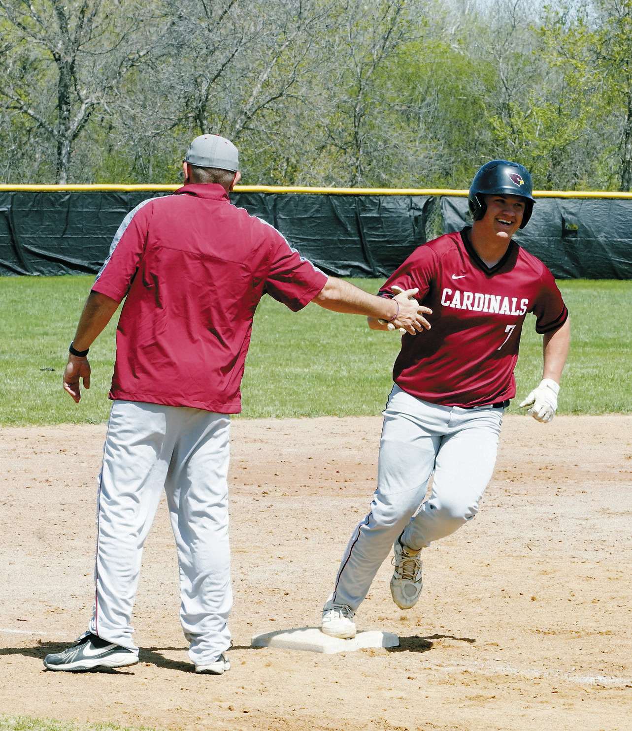 Coach K congratulates Theo Romfo for sending the ball over the fence for a home run in the Cards' win over Renville on May 10. Photo by Larry Stokke.