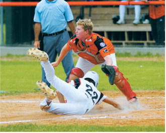 Karson Hansen dives headfirst across home plate to score a run for the Red Sox. Photo by Larry Stokke