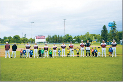 Buddy Night — Legion baseball players teamed up with local T-ball players during Buddy Night at the ballpark. The older athletes warmed up with their buddies, joined them for the starting lineup introductions and stood together during the national anthem, serving as positive role models for the next generation of players. Photo by Larry Stokke