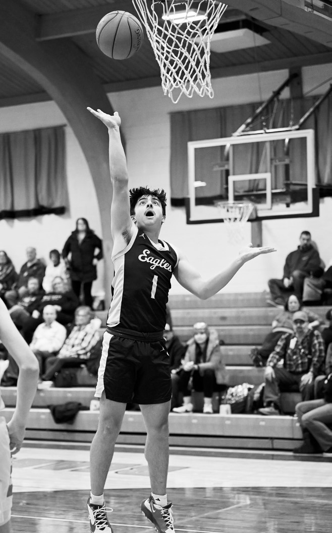 Weston Cosley drives down the lane to drop in a basket. Photo by Ashley Schafer.