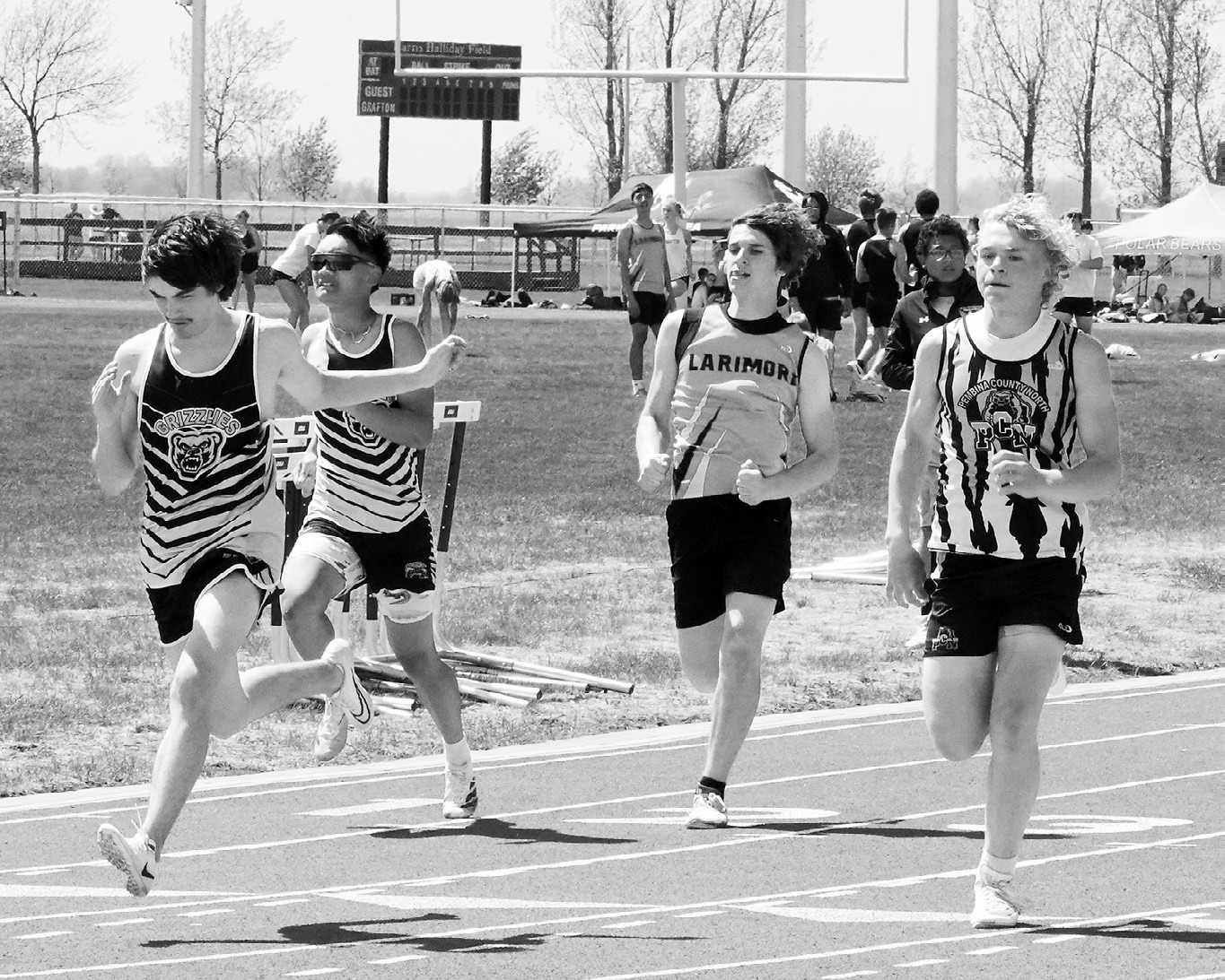 From (L-R) Boone Carrier, Lance Santiago, and Kylan Schafer competing in the 100 meter dash. Photo by Larry Stokke.