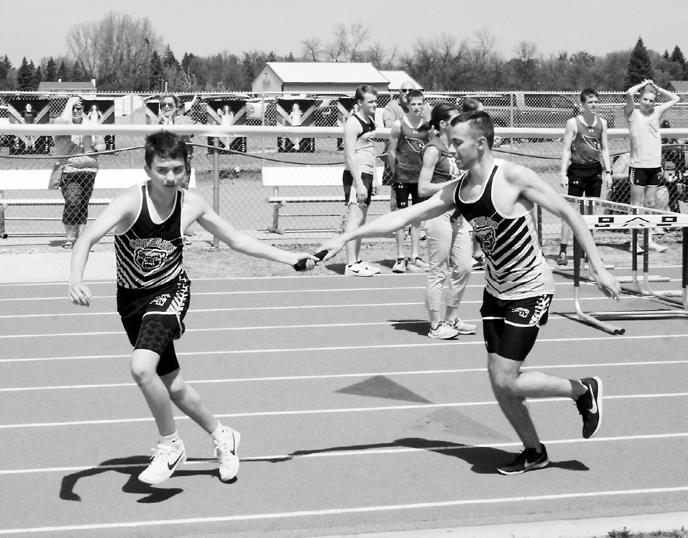 Mason Heller hands the baton to Jaxon Suedel who, along with teammates Owen Crosby and Nash Fitzsimonds, took first in the 4X400 meter relay in Grafton on May 12. Photo by Larry Stokke.