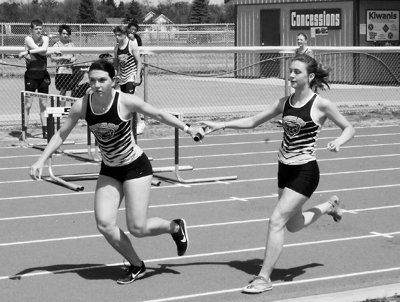 Shirley Kemp hands off the baton to Delaney Denault who, along with Maci Puppe and Emerson Helgoe, took first in the 4x800 meter relay. Photo by Larry Stokke.