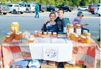 A honey stand offers a variety of locally produced honey and related products during the Walhalla Growers and Makers Market’s special night market Wednesday, Aug. 12. Photo by Larry Stokke