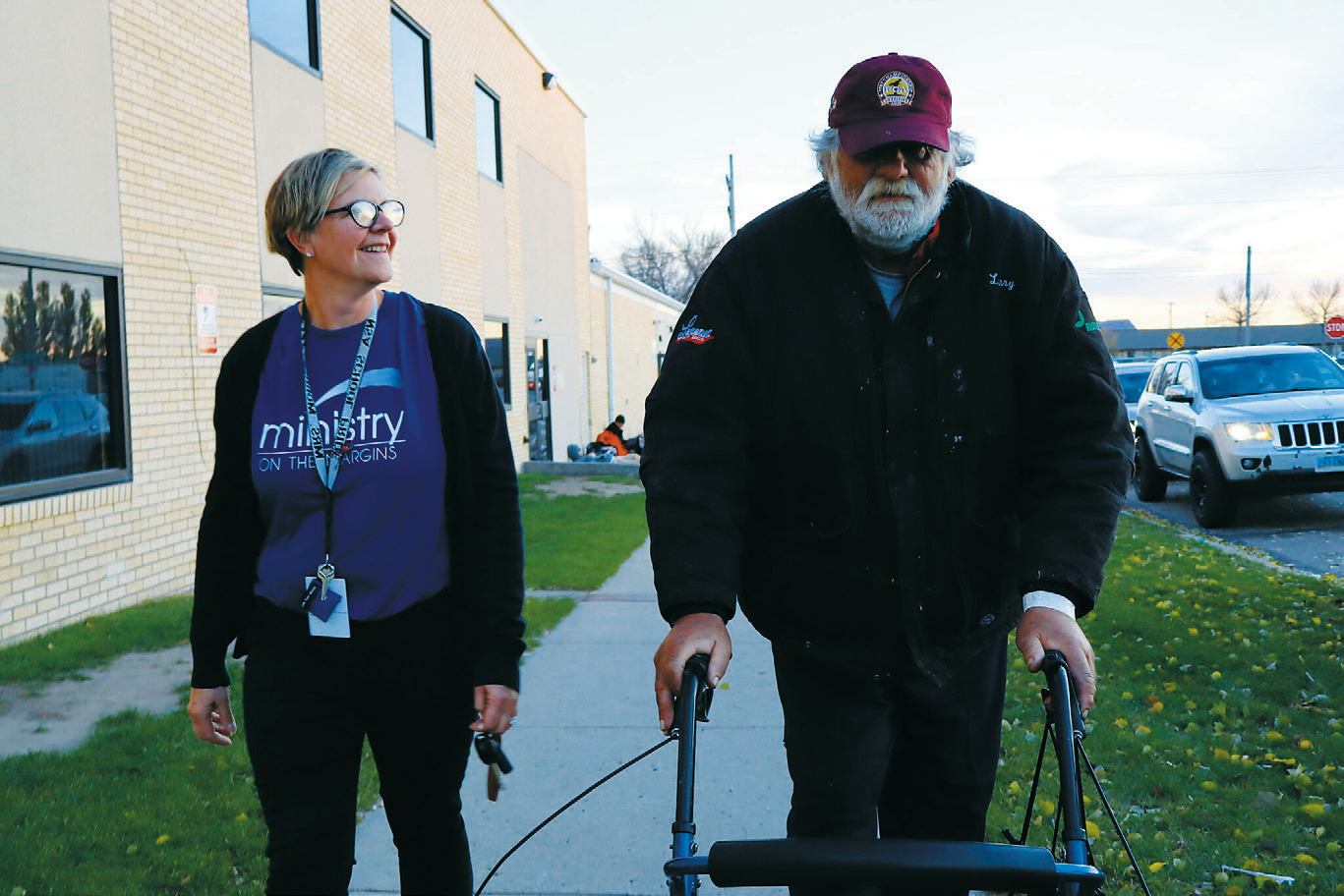 Michael Hauck, 64, right, a homeless veteran, walks next to Kris Morrissette, behavioral health manager at Ministry on the Margins in Bismarck, before being transported to a nearby hotel as he awaits approval to move into a nearby apartment on Nov. 6, 2025. (Photo by Michael Achterling/ North Dakota Monitor)