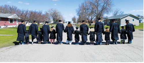 The Munich Classes of 2026 and 2038 walk hand in hand down a Munich street, symbolizing the journey from elementary school memories to graduation day and the years still to come. Submitted photo