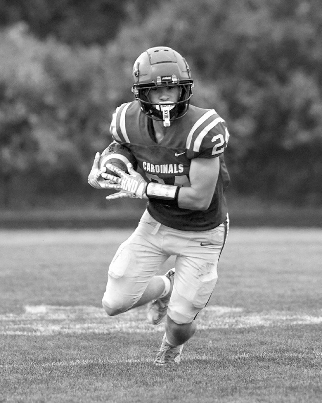 Evan Ottem carries the ball on a 14-yard touchdown run during the Cardinals’ win over Valley City. Photo by Larry Stokke