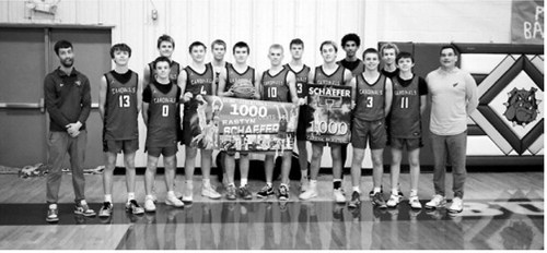 Sophomore Eastyn Schaefer celebrates 1,000 career points with his team after the Cards win against North Prairie on Feb. 9. Photo by Larry Stokke