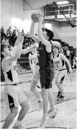 Levi Swanson FM Bank Co-Player of the Game drives into the lane and drops in a basket. Photo by Larry Stokke