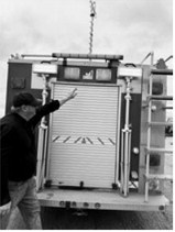 Bruce Roder shows off the rear of the truck, featuring additional lighting, storage and equipment behind the roll-up door.