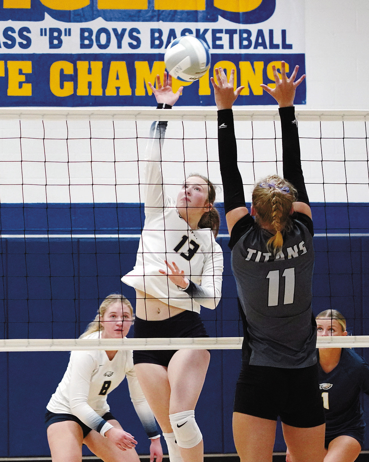 Addison Lyons sends the ball over a Titan for a point. Photo by Larry Stokke.
