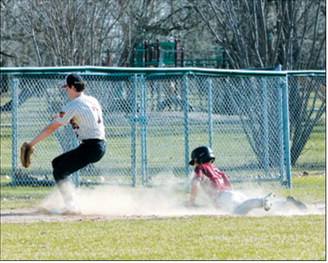 Connor Mitchell slides safely into third base during the Cardinals’ win over the Mustangs. Photo by Larry Stokke