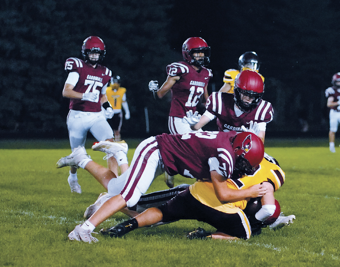 Luke Gilseth, Kade Hansen, and Gavin Trottier team up to tackle a Braves ball carrier. Photo by Larry Stokke.