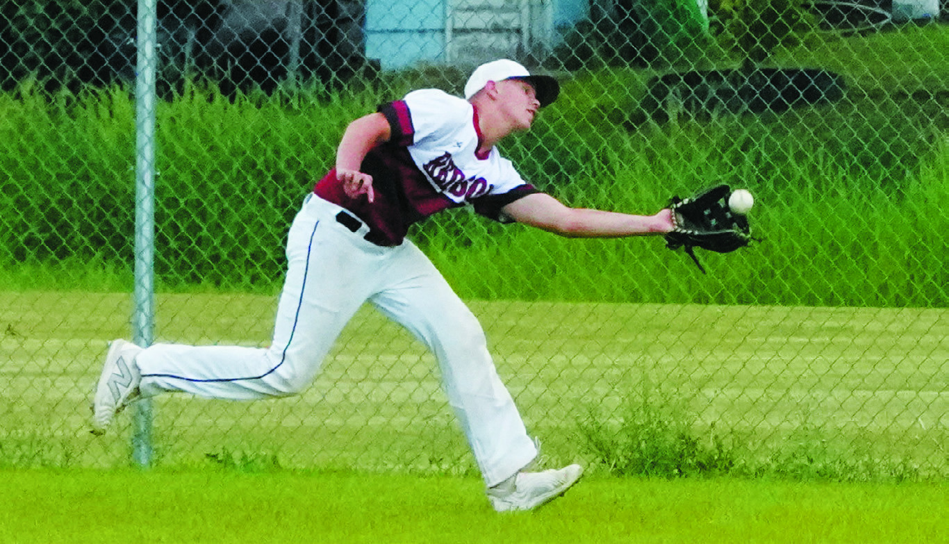 Luke Gilseth stretches out and makes a catch for an out near the right-field fence during the game against Thompson. Photo by Larry Stokke.