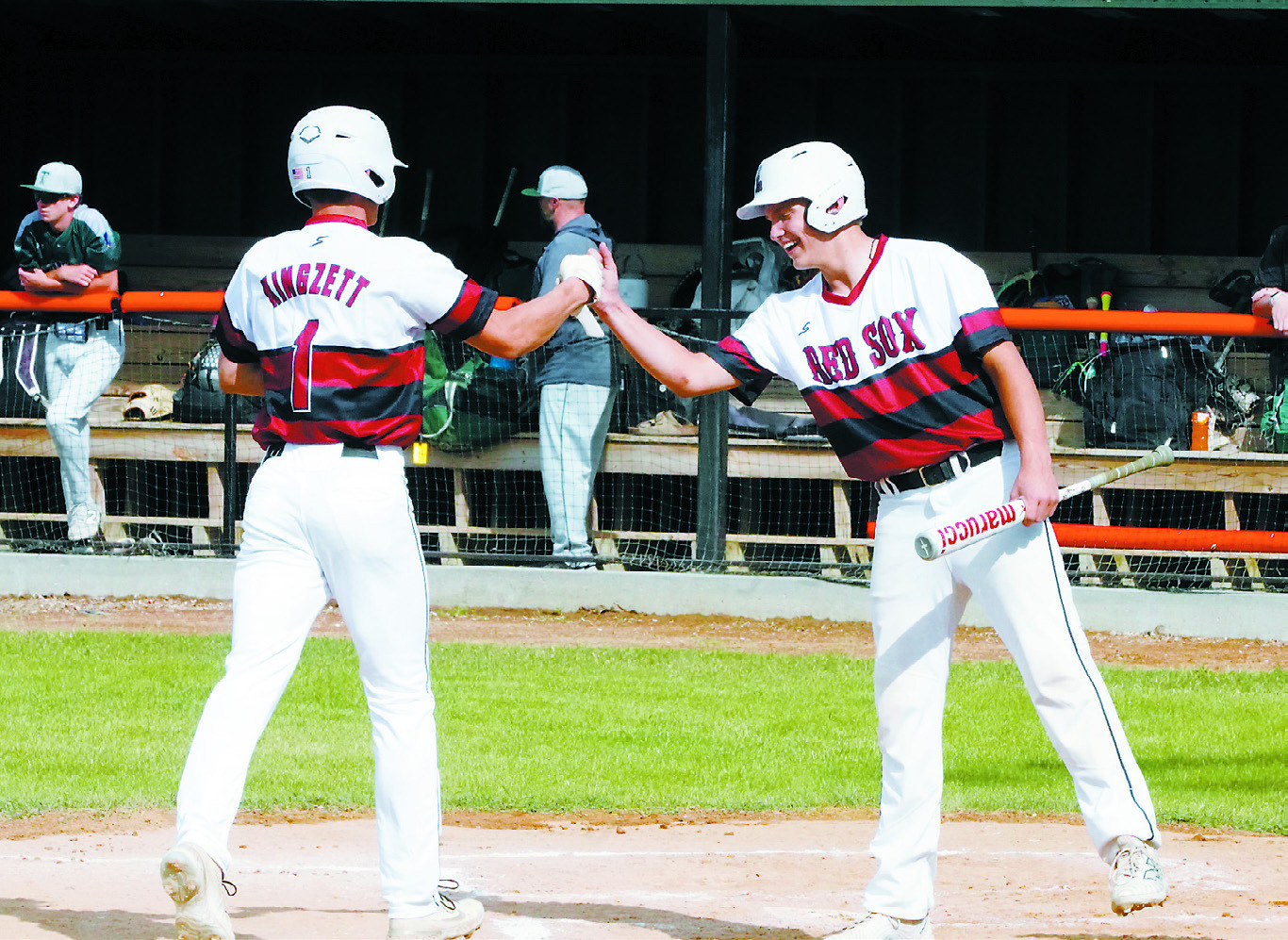 Nic Kingzett gets congratulated on his over the left-field fence hit for a home run. Photo by Larry Stokke.