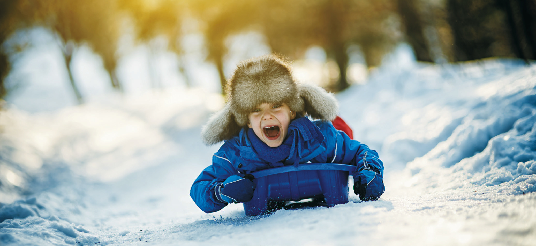 Sledding down a snow pile! Photo courtesy of Brit Dettler Farris.