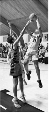 #21 Senior Brody Berg gets a shot up over an outstretched defender. Photo by Ashley Schafer