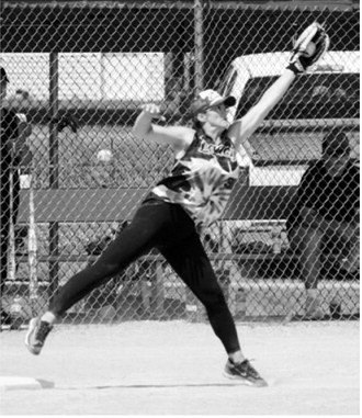 Barb Crockett stretches to make the catch at first base for an out during the co-ed softball tournament. Photo by Larry Stokke