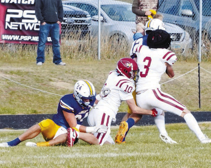 Cody Amble and Maddux Stremick wrap up the Aggie's Treyson Iglehart. Photo by Larry Stokke.