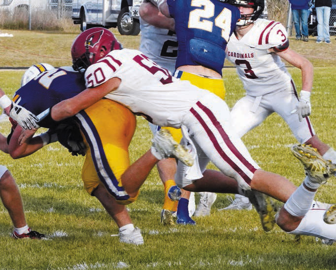 Landon Schneider wraps up an Aggie ball carrier, preventing him from scoring on the play. Photo by Larry Stokke.
