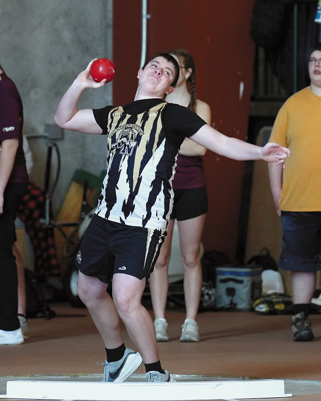 Michael O’Connor winds up and throws the shot put at the indoor meet in Grand Forks. Photo by Larry Stokke