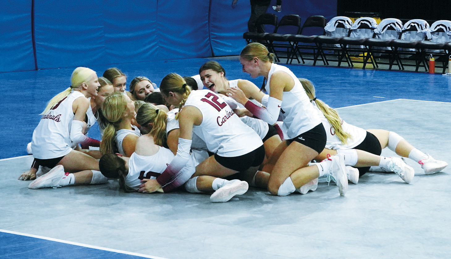 Overwhelmed with emotion, the 2024 Langdon Area-Munich volleyball team falls to the floor in celebration of their Class B State Championship win. Photo by Larry Stokke.
