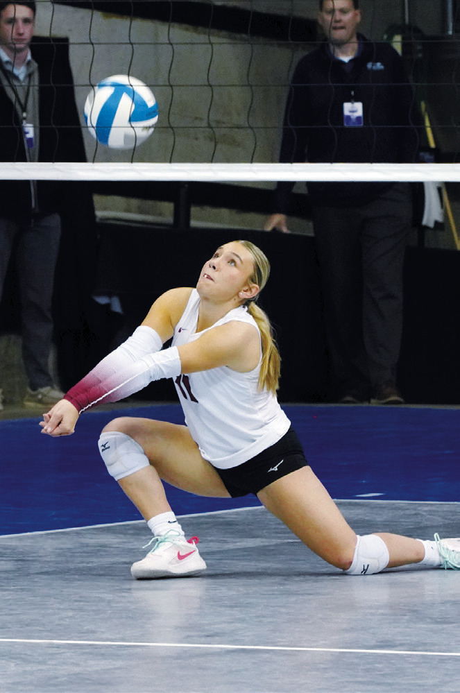 Raeleigh Ratzlaff reaches low to pass the ball over the net. Photo by Larry Stokke.