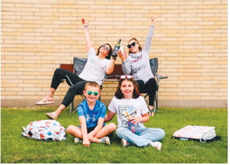 Moms Kayla Krom, back left, and Courtney Krom celebrate with humor as Ender Krom, front left, and Kamdyn Krom head off to school. Photo courtesy of Kayla Krom