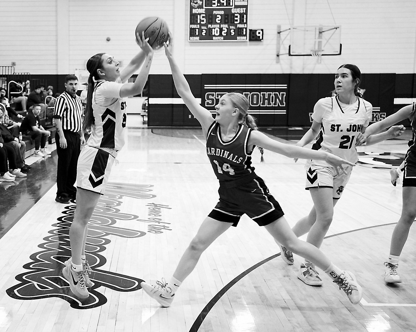 Hilary Haaven gets her hand on the ball, altering Kennley Davis's shot in St. John on Jan. 9. Photo by Larry Stokke.