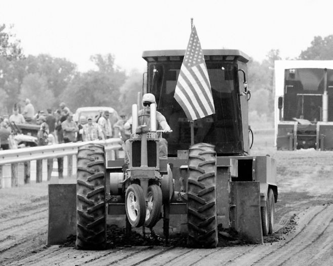 Ross Johnson pulls the front wheels up on his John Deere during the tractor pull. Photo by Larry Stokke.
