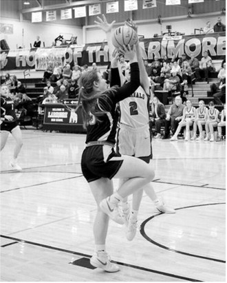 FM Bank Player of the Game Mya Swanson gets her hands on the ball blocking an Aggies shot in the Cards win over Park River in the first round of Regionals. Photo by Larry Stokke