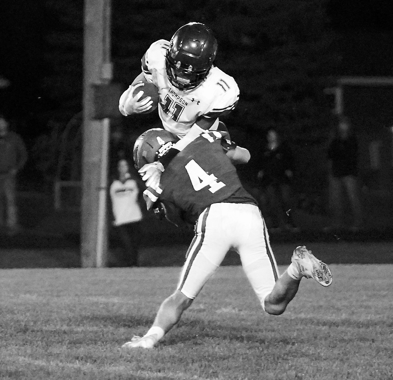Sam Davis knocks wide receiver Joe Taylor off his feet to stop him from gaining any yardage. Photo by Larry Stokke.