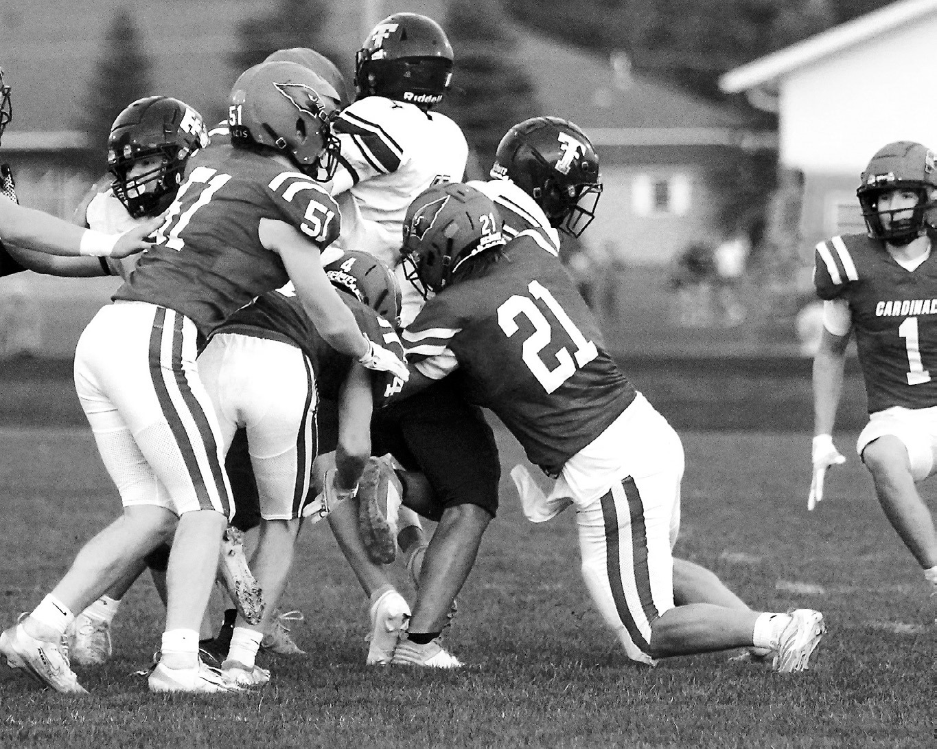 Seniors Theo Romfo, Keaton Ullyott, and Sam Davis team up to tackle a Tommie ball carrier in the Cards' win over the Tommies. Photo by Larry Stokke.