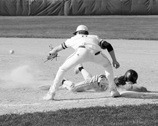 Landon Schneider slides back to first base against Grafton. Photo by Larry Stokke.