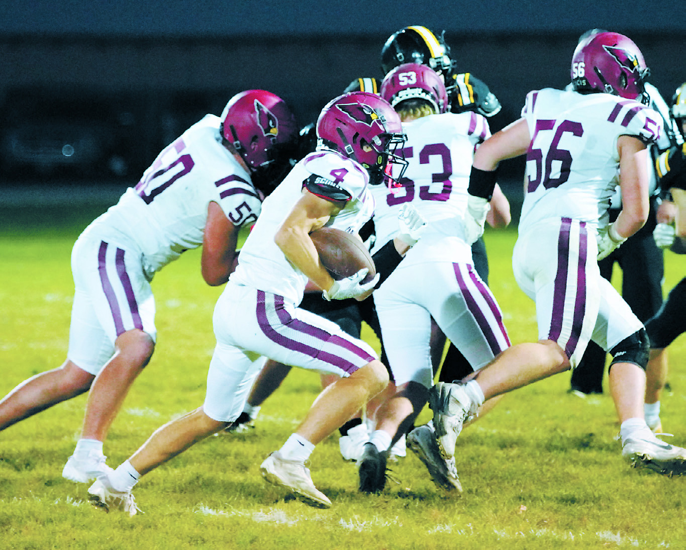 FM Bank's Player of the Game Sam Davis gets room to run with help from his teammates. Sam finished the game with 20 carries for 193 yards and two touchdowns. Photo by Larry Stokke.