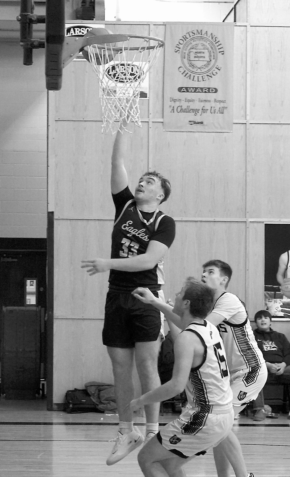 Kade Schafer lays in a basket, and along with a pair 3-pointers, finished the game with 12 points. Photo by Larry Stokke.