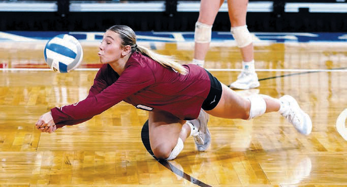 Raeleigh Ratzlaff makes a diving dig against EKM. Photo by Larry Stokke.